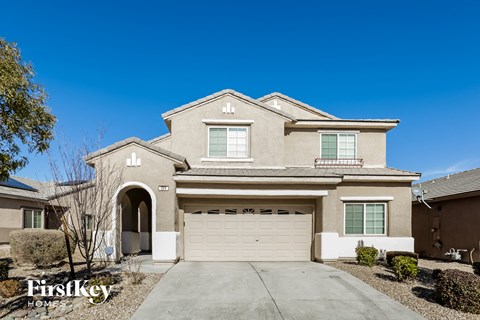 a beige house with a garage and a driveway