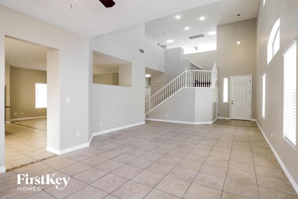 an empty living room with a staircase in a house