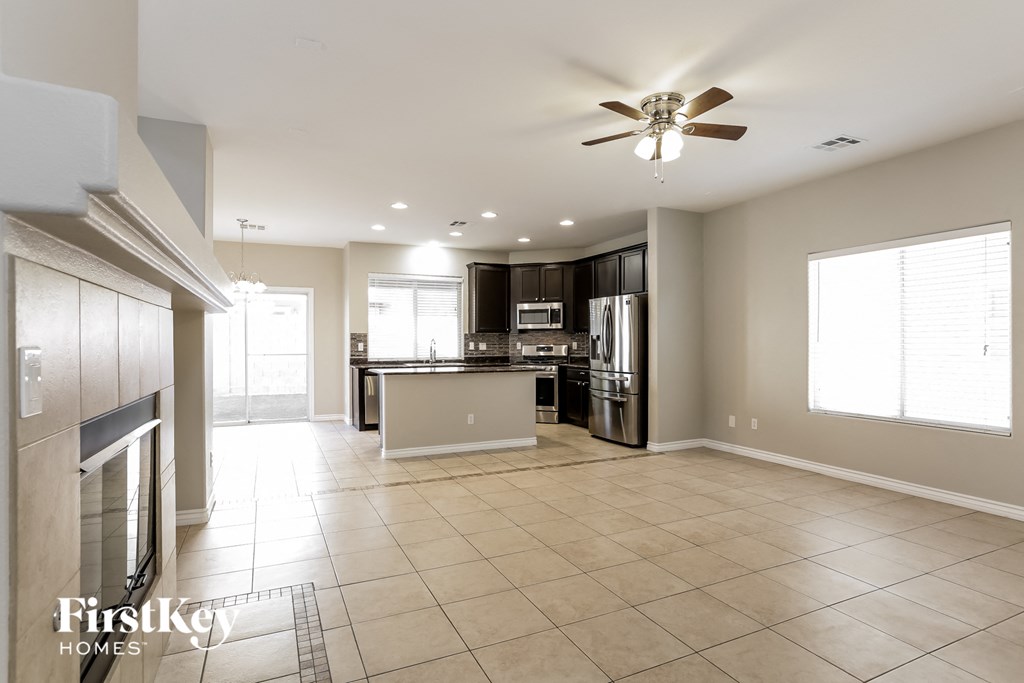 an open kitchen and living room with a fireplace and tile flooring