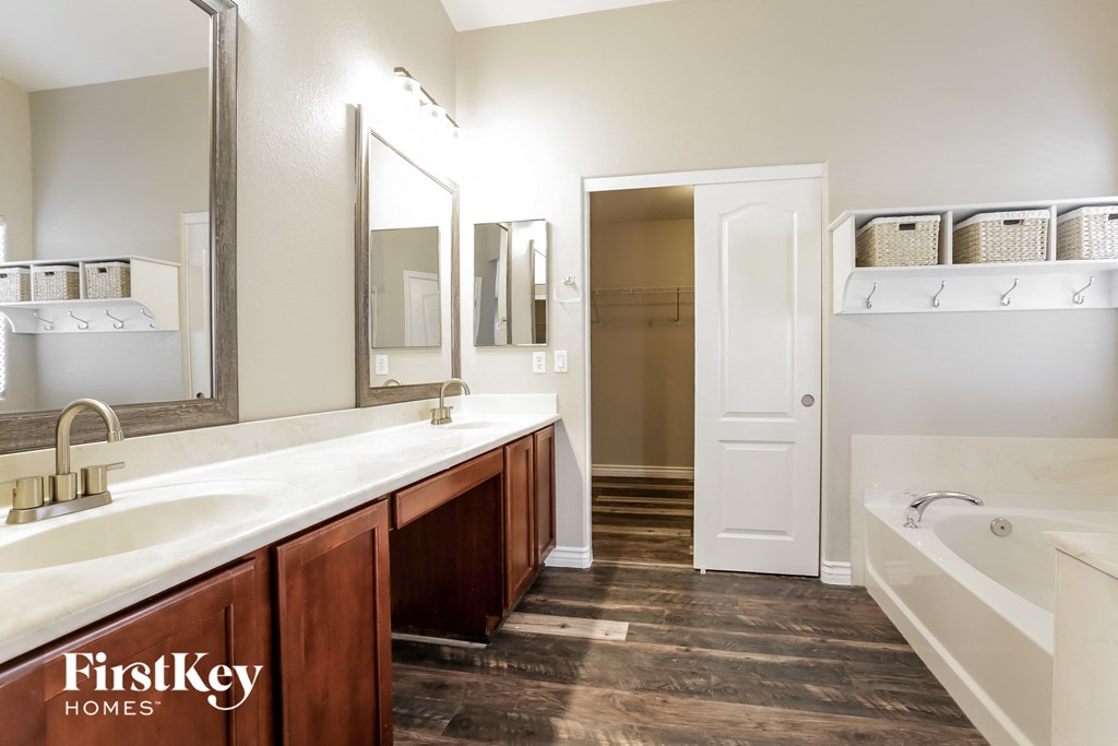 a bathroom with a tub and a sink and a mirror