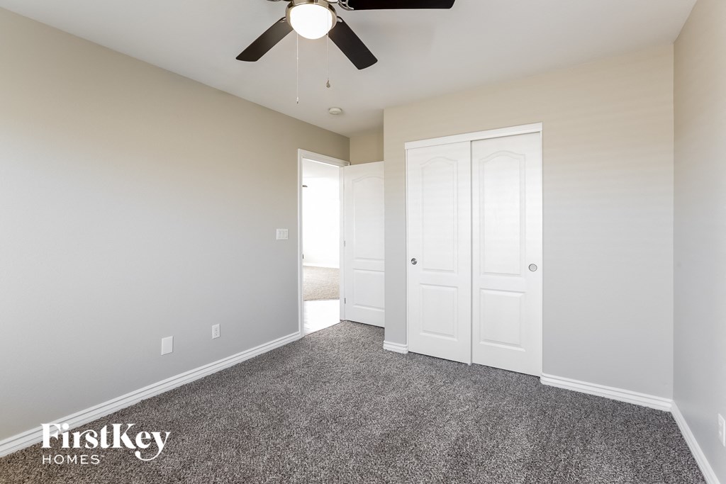 a bedroom with a ceiling fan and a closet