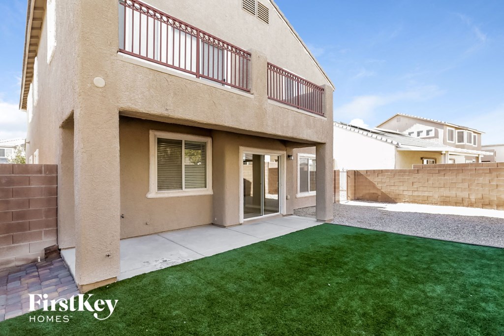 the backyard of a house with green grass and a patio