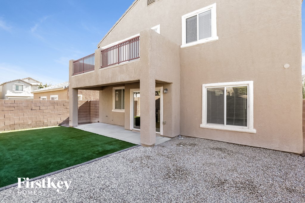 the backyard of a house with a green lawn and a patio
