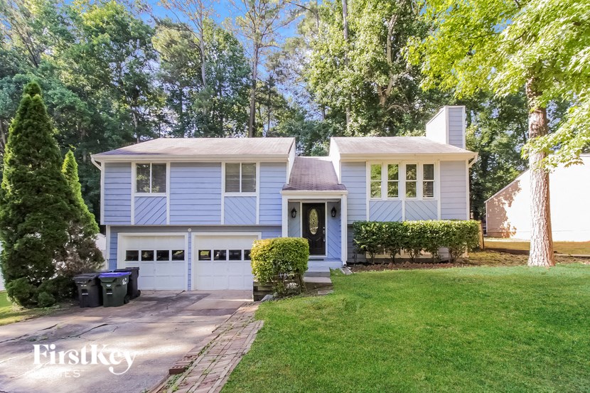 a blue house with a lawn and a driveway