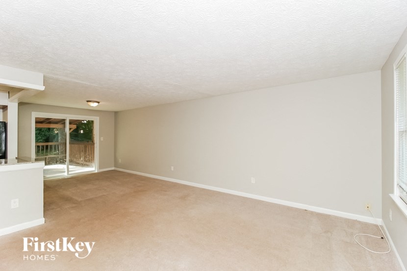 an empty living room with a door to a patio