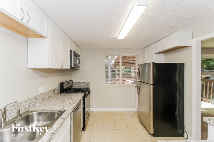 a kitchen with a stainless steel refrigerator and a sink