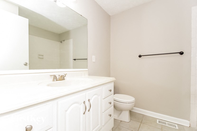 a bathroom with a large mirror and a sink and a toilet