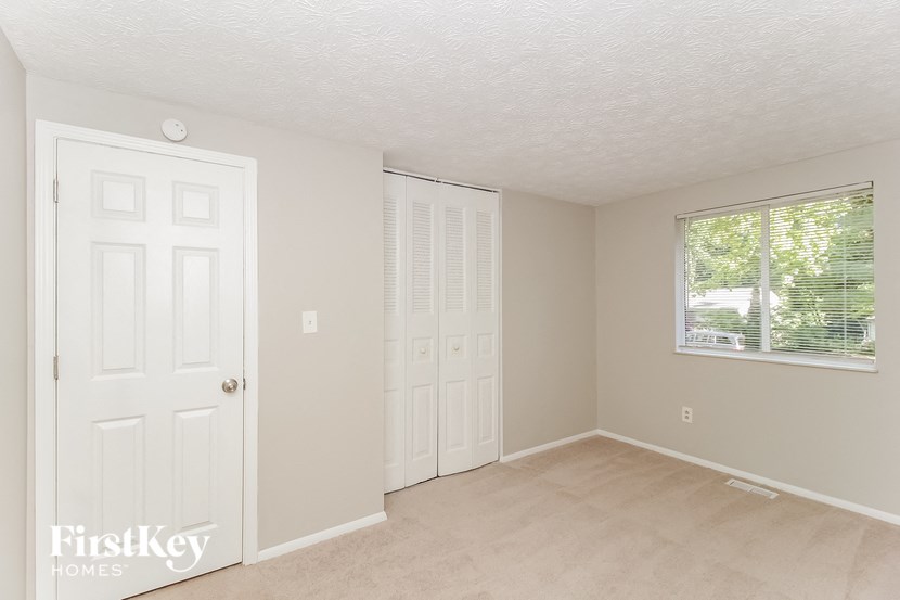 a bedroom with a white door and a window