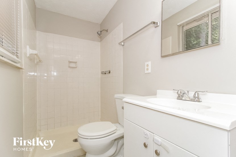 a white bathroom with a sink toilet and shower