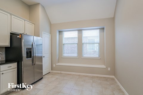 a kitchen with a large window and a refrigerator