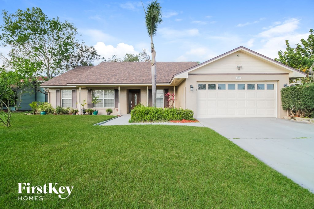 A house with a garage and a driveway in front of it.