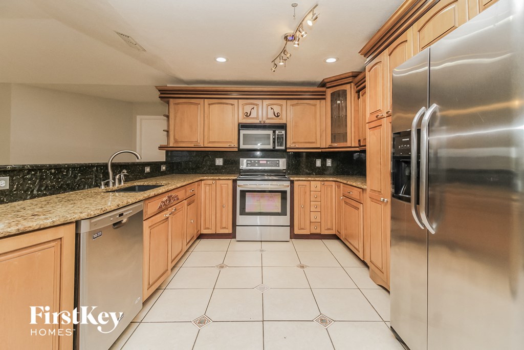 A kitchen with wooden cabinets and a stainless steel refrigerator.