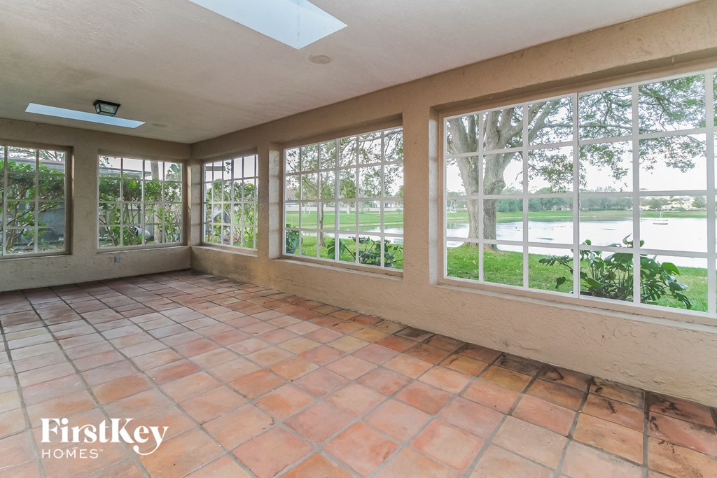 A sunroom with a skylight and tile flooring.