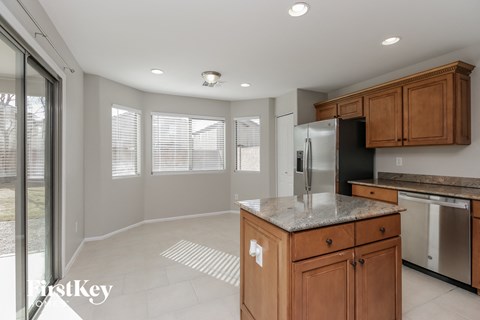 A kitchen with wooden cabinets and a granite countertop.