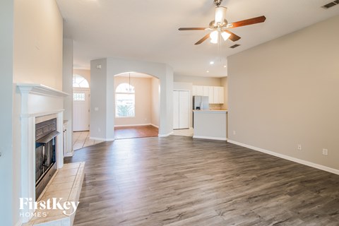 A spacious living room with a fireplace and hardwood floors.
