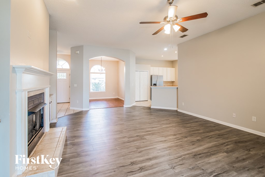 A spacious living room with a fireplace and hardwood floors.