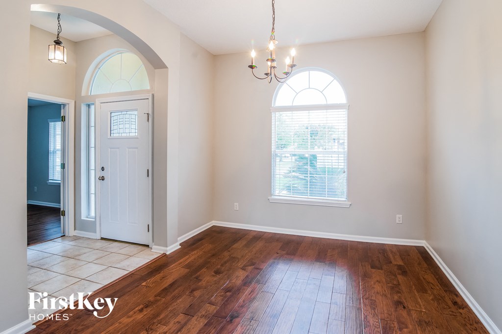 A room with a wooden floor and a chandelier.