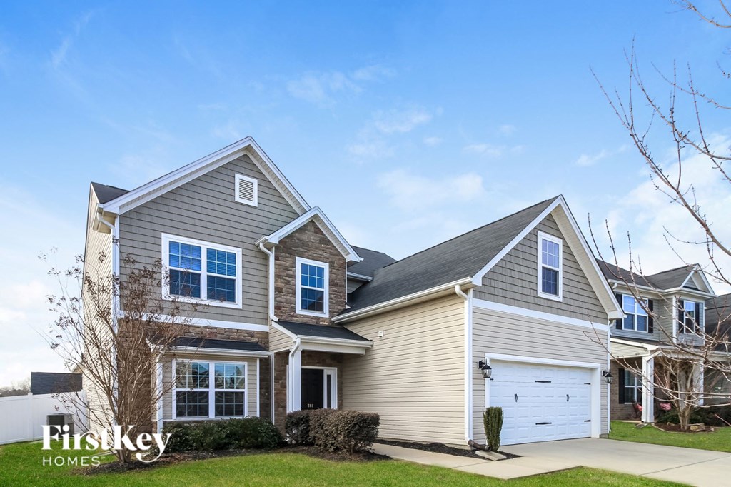 A large, two-story house with a garage is showcased in the image.