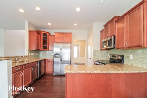 A kitchen with brown cabinets and a marble countertop.