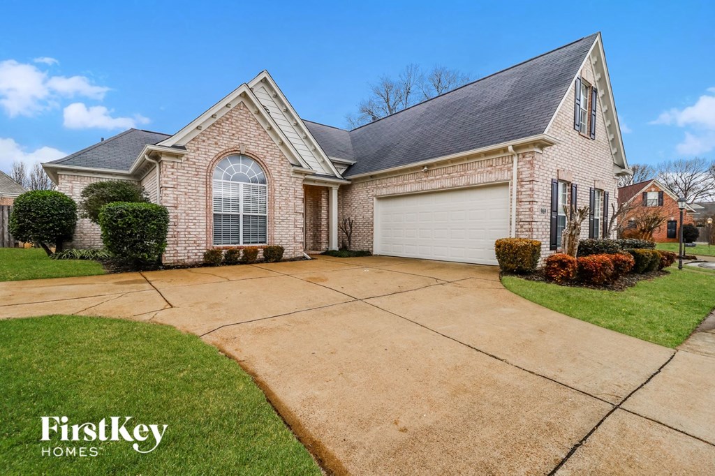 a large brick house with a driveway and lawn