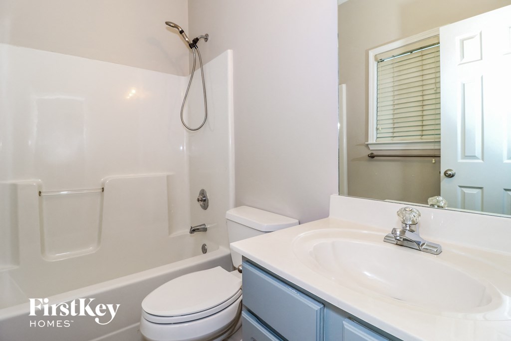a bathroom with a sink toilet and shower and a mirror