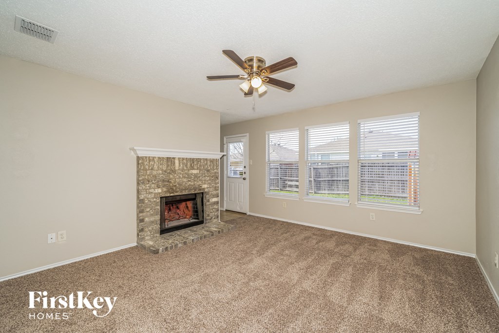 a living room with a fireplace and a ceiling fan