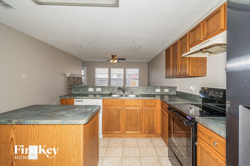 a kitchen with granite counter tops and wooden cabinets