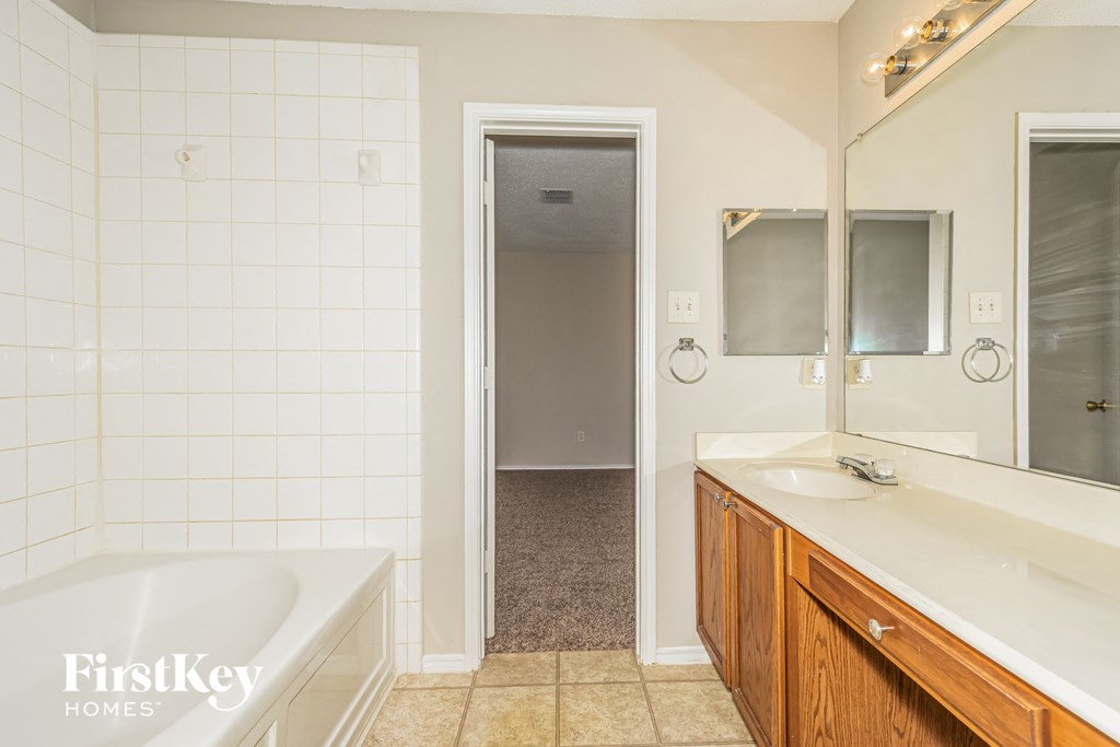 a bathroom with a tub and a sink and a mirror