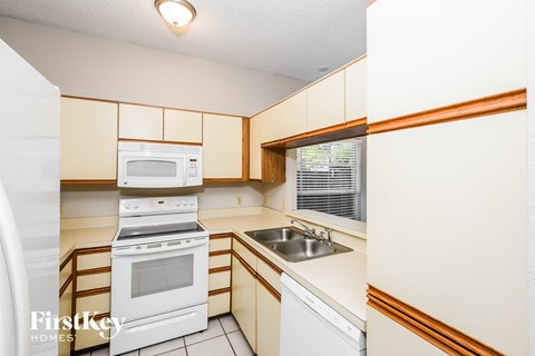 a kitchen with white appliances and white cabinets
