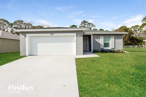 a white house with a white garage door and a lawn