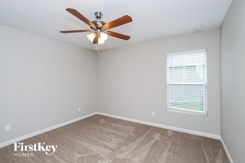 a bedroom with a ceiling fan and a window