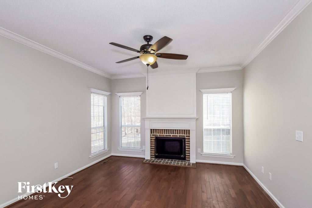 a living room with a ceiling fan and a fireplace