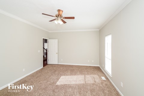 a living room with carpet and a ceiling fan