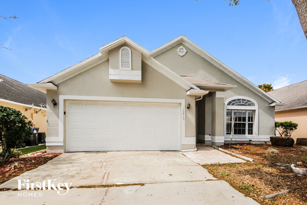 A two-story house with a garage and a driveway.