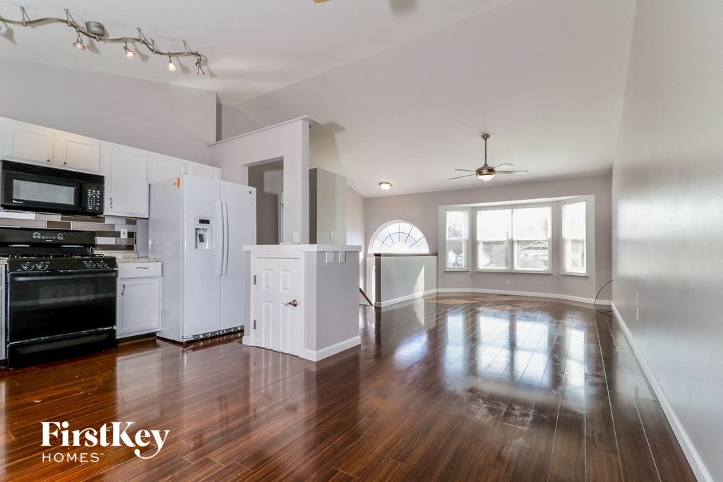 A kitchen with wooden floors and white appliances.