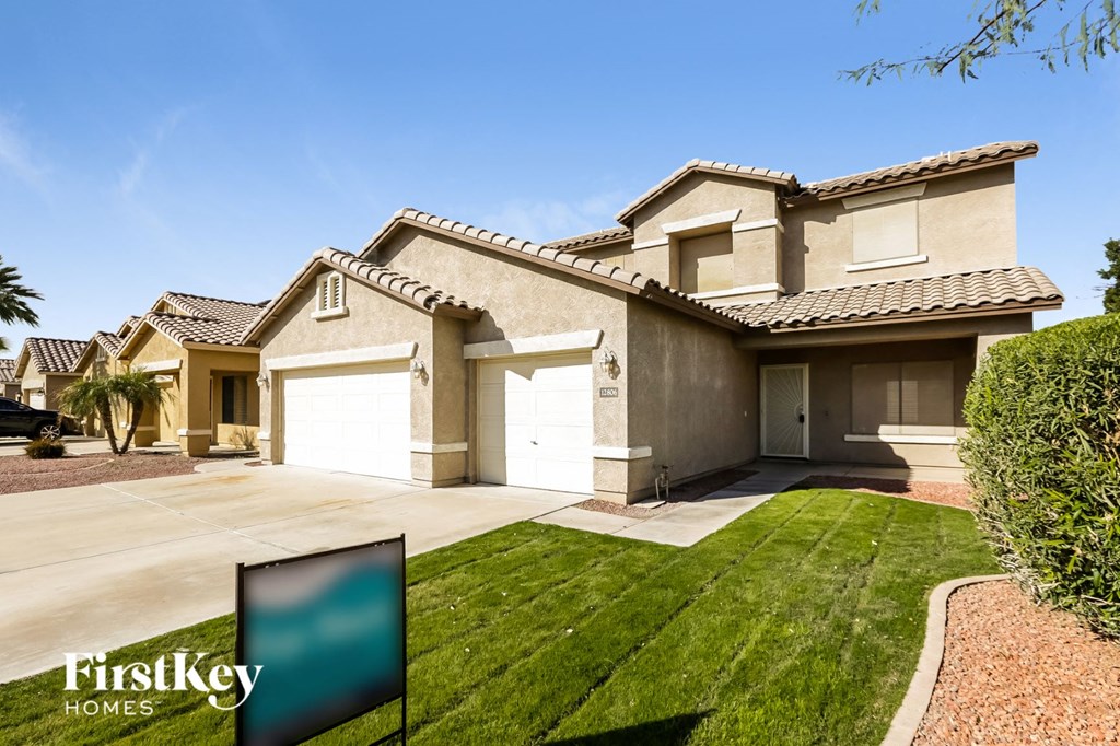 a house with two garage doors and a lawn