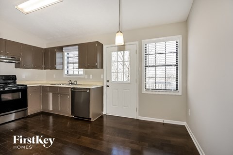 an empty kitchen with stainless steel appliances and a window