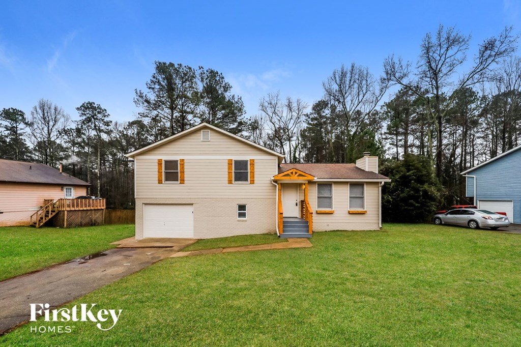 a white house with a yard and a car in the driveway