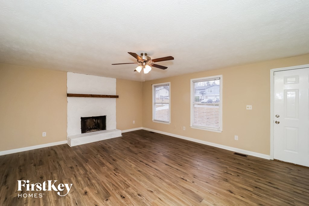 a living room with a fireplace and a ceiling fan
