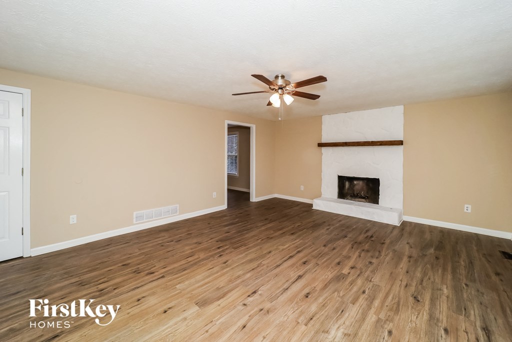the living room with wood floors and a fireplace