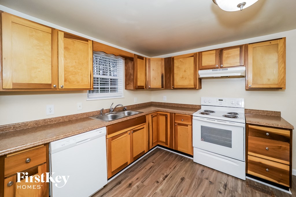 a kitchen with white appliances and wooden cabinets