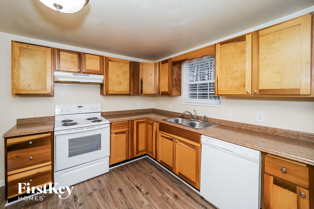 a kitchen with white appliances and wooden cabinets