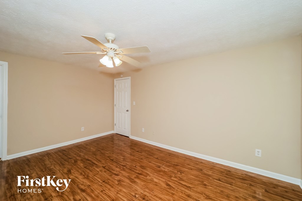 a bedroom with wood flooring and a ceiling fan