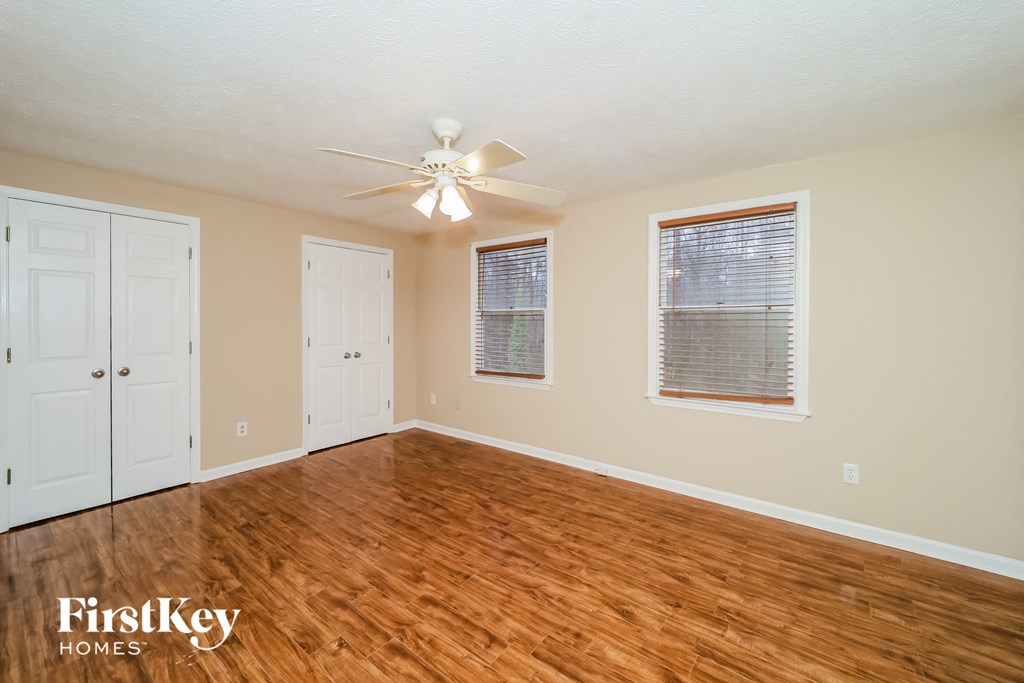 a living room with a hard wood floor and a ceiling fan