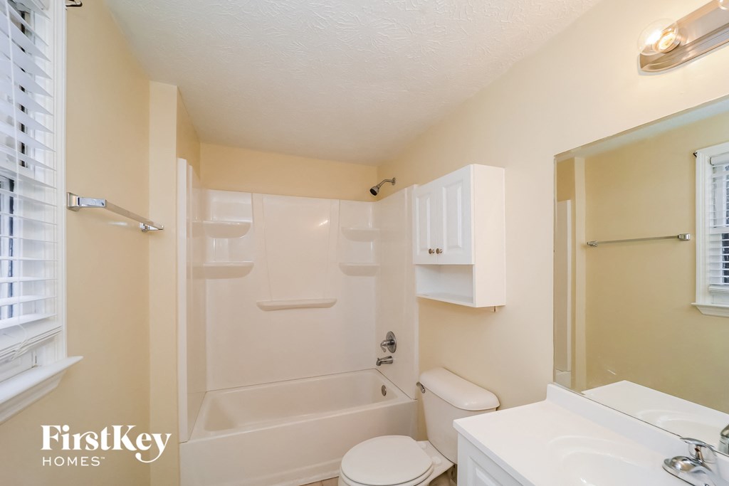 a bathroom with a white toilet and a tub and a sink