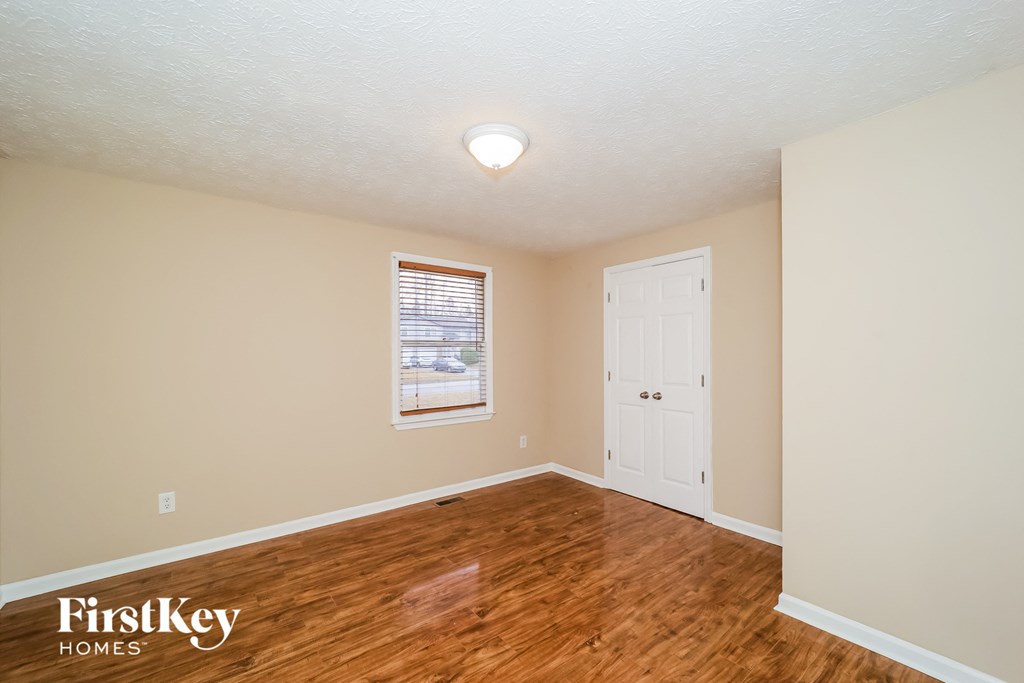a living room with a hard wood floor and a white door