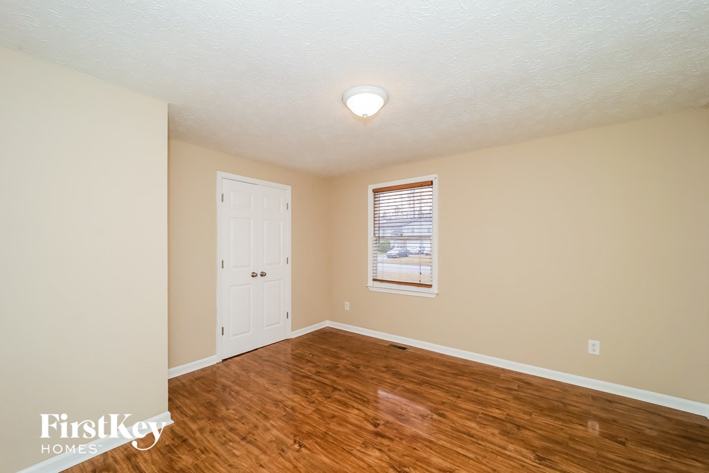 a living room with a hard wood floor and a white door