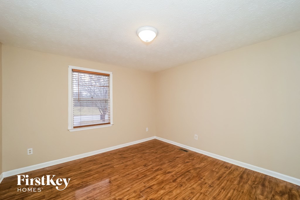 the living room of a house with a hardwood floor and a window