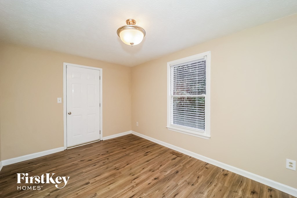 the living room of a house with a wooden floor and a white door