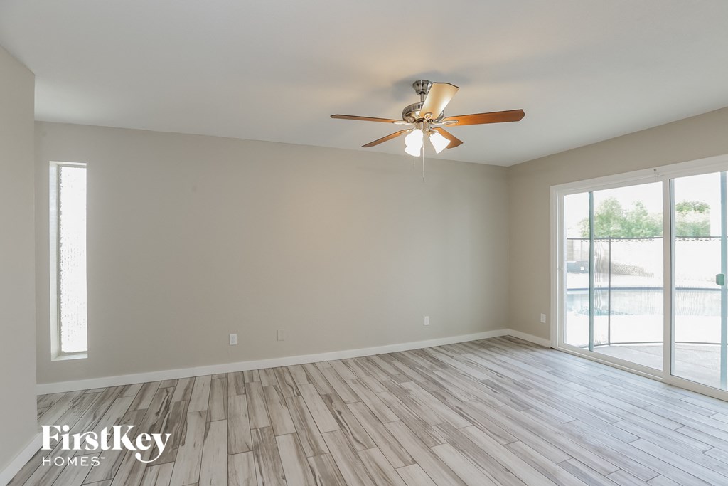 A room with a ceiling fan and wooden flooring.